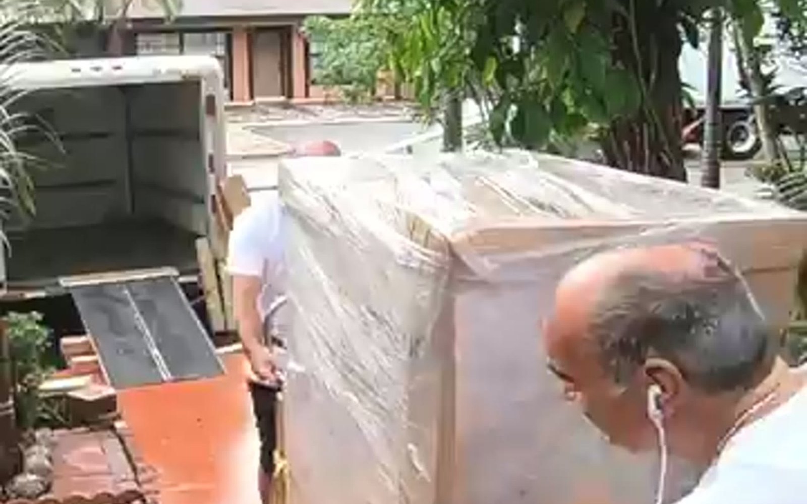 A&T Moving and Hauling crew wheeling a wrapped piece to the truck in Rockland County